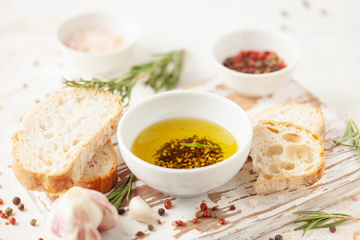 Bread dipping oil. Crusty bread ciabatta and bowl of olive oil with spices.