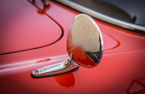A mirror on a drivers side, on a black sports coupe.
