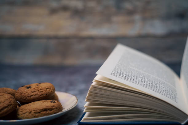 Open book next to a plate of cookies. High quality photo