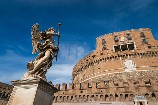 Rome, Italy, november 23, 2022 : Angel with the Spear by Domenico Guidi and Castel Sant'Angelo from Rome