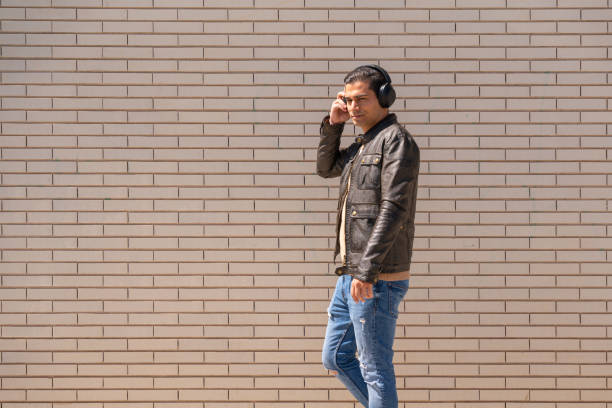 Handsome man putting on a headset in the street