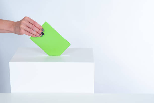 Man hand puts a ballot paper into a voting box. Voting box on a white background. Concept - democratic elections. Providing political elections. Voting for candidates. Person makes his choice.