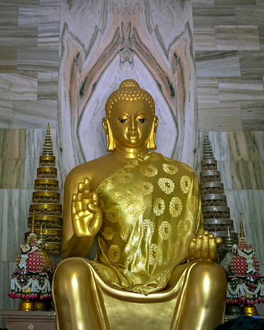 Close up image of Huge golden statue of sitting Buddha outside Thai temple in Sarnath near Varanasi.