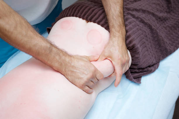 A masseur performing a back massage on a patient.