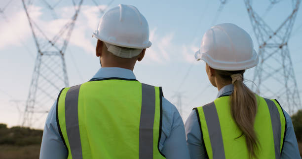 istock Construction, electricity and renewable energy with helmet and engineering for eco friendly planning. Teamwork, sustainability and back of technician people with collaboration and power work 2150017021