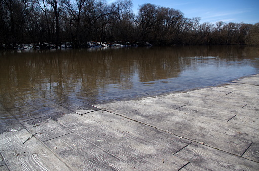 flooded embankment in the city of Serpukhov, spring flood, sunny day, blue sky