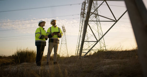 istock People, electrical engineer and tablet in power plant with discussion for electricity transmission and tower check. Engineering, inspection and collaboration for energy distribution and maintenance 2150017408