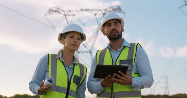 istock Teamwork, electrical engineer and construction in power plant with tablet for electricity inspection or tower check. Engineering, transfer or collaboration with people distribution or maintenance 2150017417