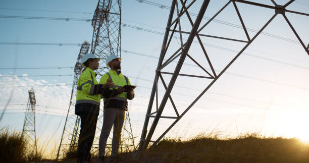 istock Teamwork, electrical engineer and tablet in power plant with inspection for electricity transmission and tower check. Engineering, voltage app or collaboration for energy distribution and maintenance 2150017422