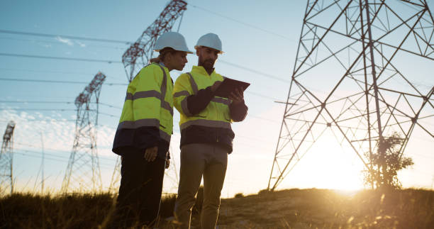 istock Teamwork, electrical engineer and tablet in power station with sunset for electricity transmission and data transfer. Engineering, workers and collaboration for energy distribution and maintenance 2150017424