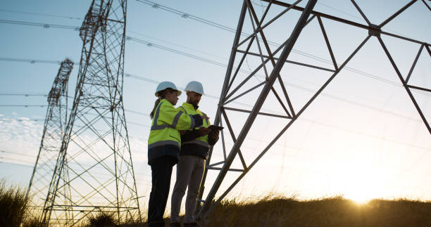 istock Teamwork, electrical engineer and tablet in power plant with inspection for electricity transmission or tower check. Engineering, collaboration or data transfer for energy distribution or maintenance 2150017425
