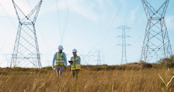 istock Teamwork, electrical engineer and tablet in power palnt with discussion for electricity transmission and tower check. Engineering, workers and collaboration for energy distribution or mockup in field 2150017430