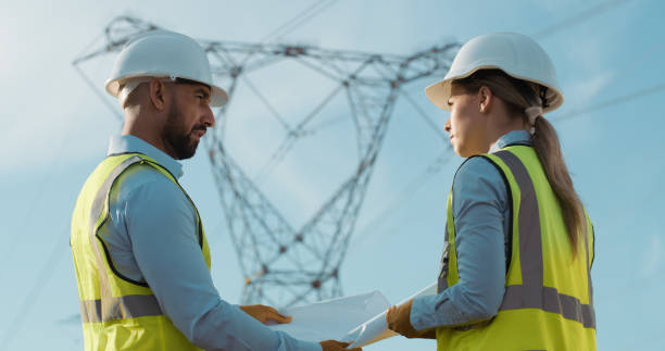 istock Construction, people and renewable energy with engineering and eco friendly project planning. Teamwork, sustainability industry and electrical employee or technician with blueprint and power work 2150017433