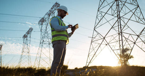 istock Man, tablet and electrical engineer with engineering in power plant to test electricity transmission system or safety check. Inspection, sunset and tech app for energy distribution or turbine control 2150018080