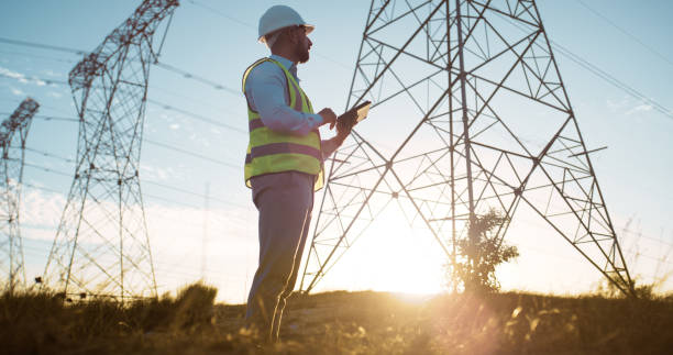 istock Engineering, tablet and man at electricity tower on inspection, maintenance or distribution of renewable energy. Contractor, technician or electrician on digital app for power sustainability at pylon 2150018085