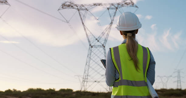 istock Woman, engineering and equipment or document for electricity in Australia, industrial project with power. Female engineer, energy and helmet with paperwork or tablet in field, checking or maintenance 2150018325