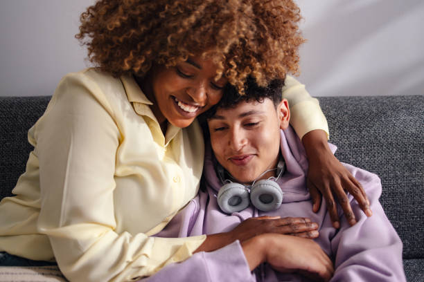 istock Affectionate Mom Embracing Teen Son on the Couch 2150019552