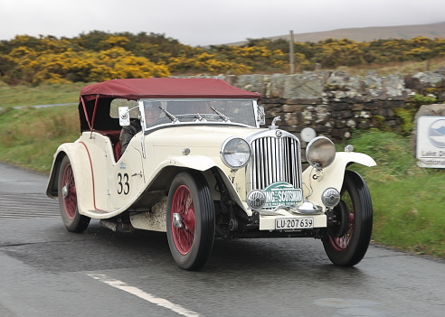 Caldbeck, England - April 13:  A 1936 AC 16 80 leaves Caldbeck, Cumbria on April 13, 2024.  The car is taking part in the Flying Scotsman Rally, a free public-event.