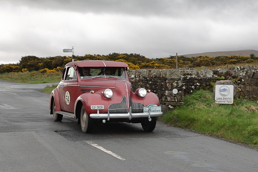 Caldbeck, England - April 13:  A 1939 Buick Century 66S leaves Caldbeck, Cumbria on April 13, 2024.  The car is taking part in the Flying Scotsman Rally, a free public-event.