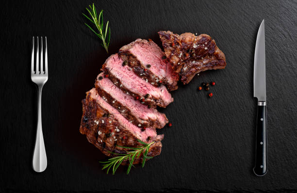 istock Rib eye beef sliced on black flavored stone with fork knife 2150022117
