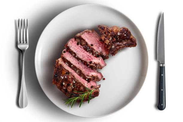 istock Rib eye beef cut in white round plate flavored with knife and fork 2150022307