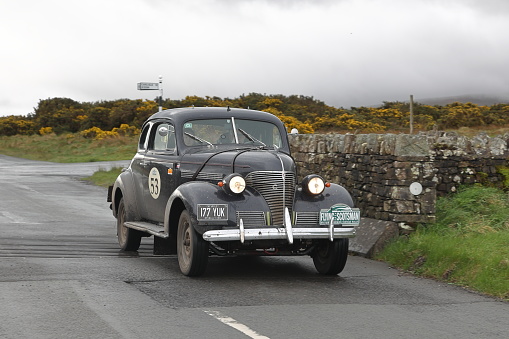 Caldbeck, England - April 13:  A 1939 Chevrolet Master Coupe leaves Caldbeck, Cumbria. The car is taking part in the Flying Scotsman Rally, a free public-event.