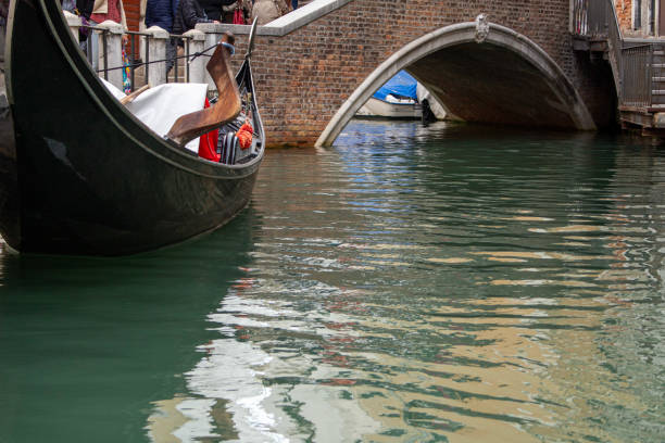 Gondola floating on the Venice Canal with a bridge in the background