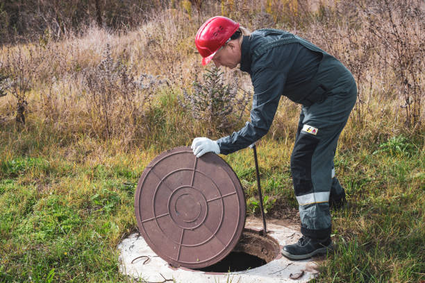 istock On a septic sewer well, a worker opens the manhole cover. Plumbing work 2150025606