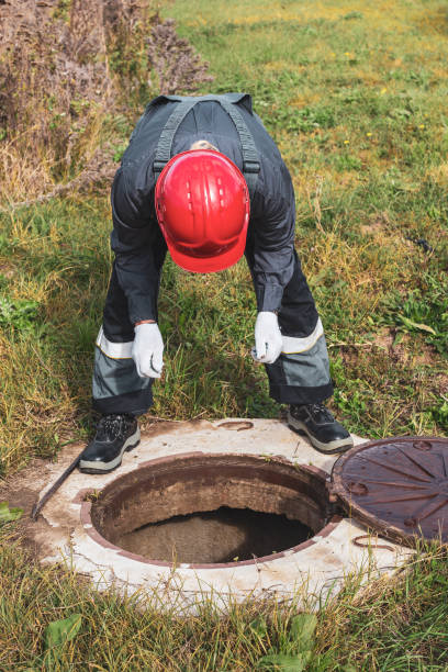 istock A worker looks into a septic sewer well, checking for water accumulation. Plumbing work 2150025608