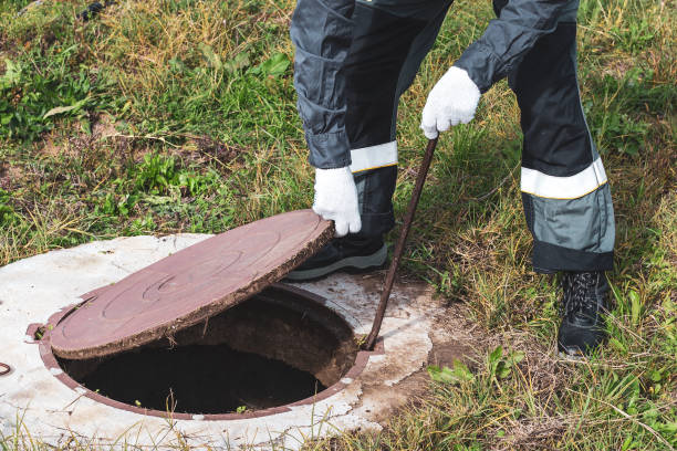 istock On a septic sewer well, a worker opens the manhole cover. Plumbing work 2150025610