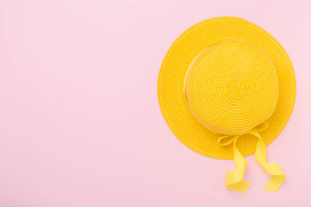 色の背景に黄色い帽子、上面図。夏のコンセプト