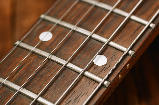 Closeup view of an electric guitar's fretboard