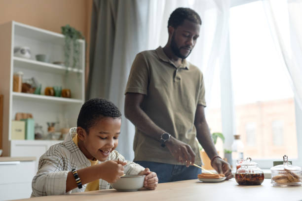 istock Black Family Eating Breakfast at Kitchen Table 2150029112