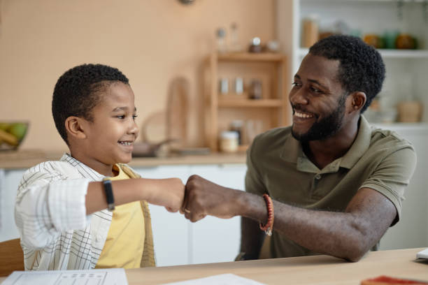 istock Happy Father and Son Fist Bump Doing Homework 2150029152