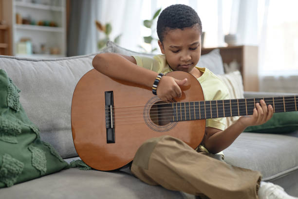 istock African American boy playing guitar at home 2150029160