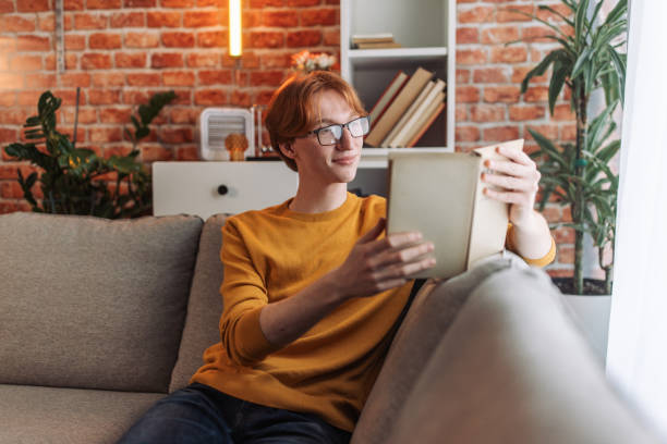 istock Focused individual reading by a brick wall 2150030349