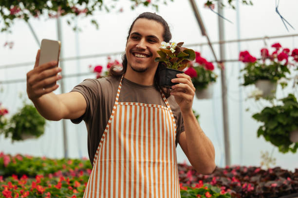 istock Man taking selfie with plant in greenhouse setup 2150031390
