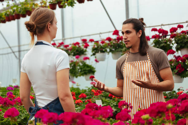 istock Man and woman talking amidst red flowers 2150031392