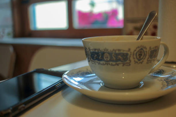 a cup of coffee and a mobile phone first thing in the morning