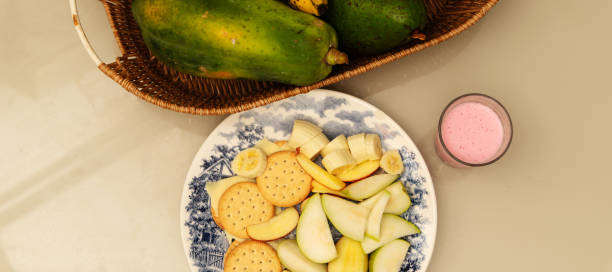 istock Breakfast plate with banana, apple, pear, biscuit, cheese and yogurt on a table. 2150036891