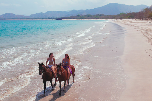 Two Women Riding Horses Bareback on the beach