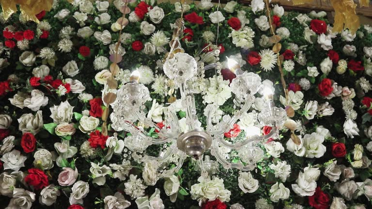 An elaborate photo highlights the lovely white chandelier adorning the backdrop of floral decorations