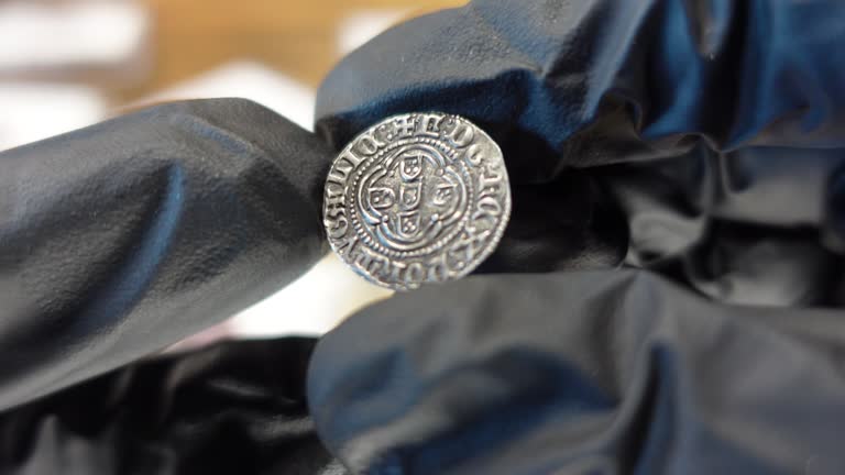Collector examining Portuguese gold coin from the Medieval Age