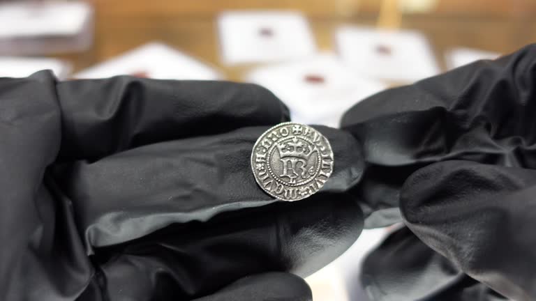 Collector examining Portuguese Silver coin from the Medieval Age