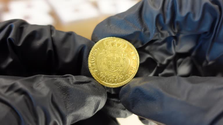 Collector examining Portuguese golden coin