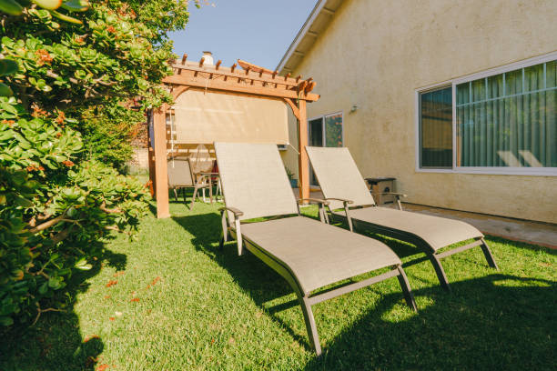istock Backyard with two lounge chairs beside a pergola on a sunny day. 2150038800