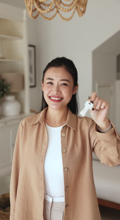Vertical portrait Asian woman showing bunch of keys to camera