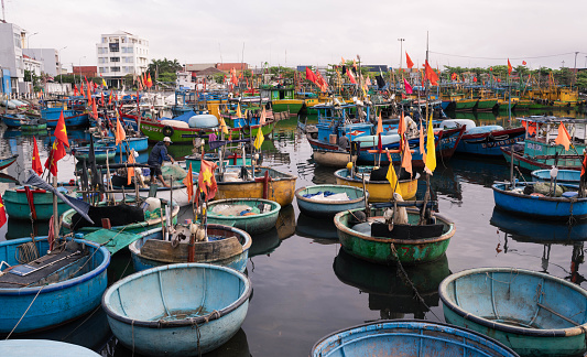 Ho Chi Minh City, Vietnam - March 2, 2024: Early morning at the bay of Ho Chi Minh City. Fishermen use traditional round boats. They are preparing for fishing. Sometimes these round boats were used to row out larger ships.