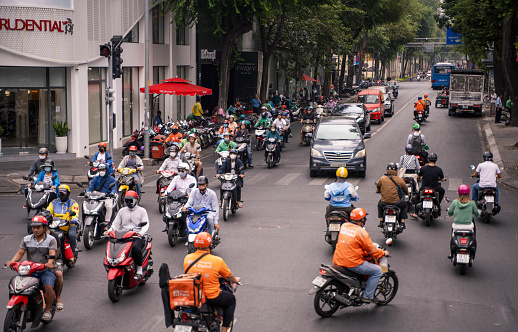 Ho Chi Minh City, Vietnam - March 4, 2024: Many motorcycles and bicycles depart from the traffic lights in central Ho Chi Minh City, chaotic traffic is a difficulty in Vietnam