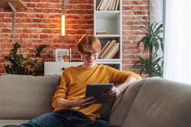 istock Relaxed person browsing a tablet on a couch 2150041670